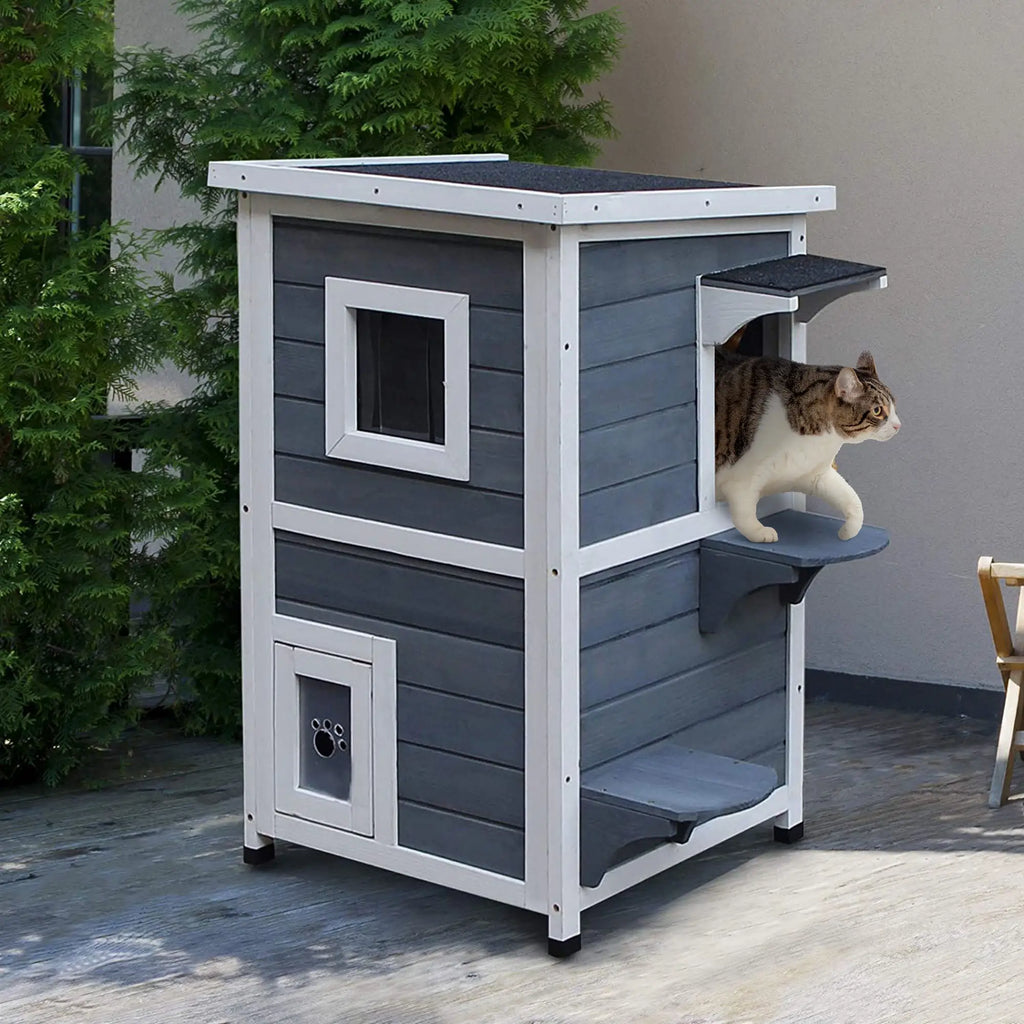 Cat house with a cat on the top level, set against a neutral background.