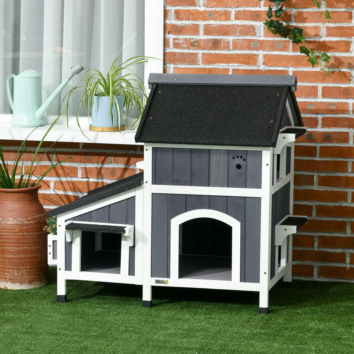 Raised two-tier wooden outdoor cat house with a sloping asphalt roof