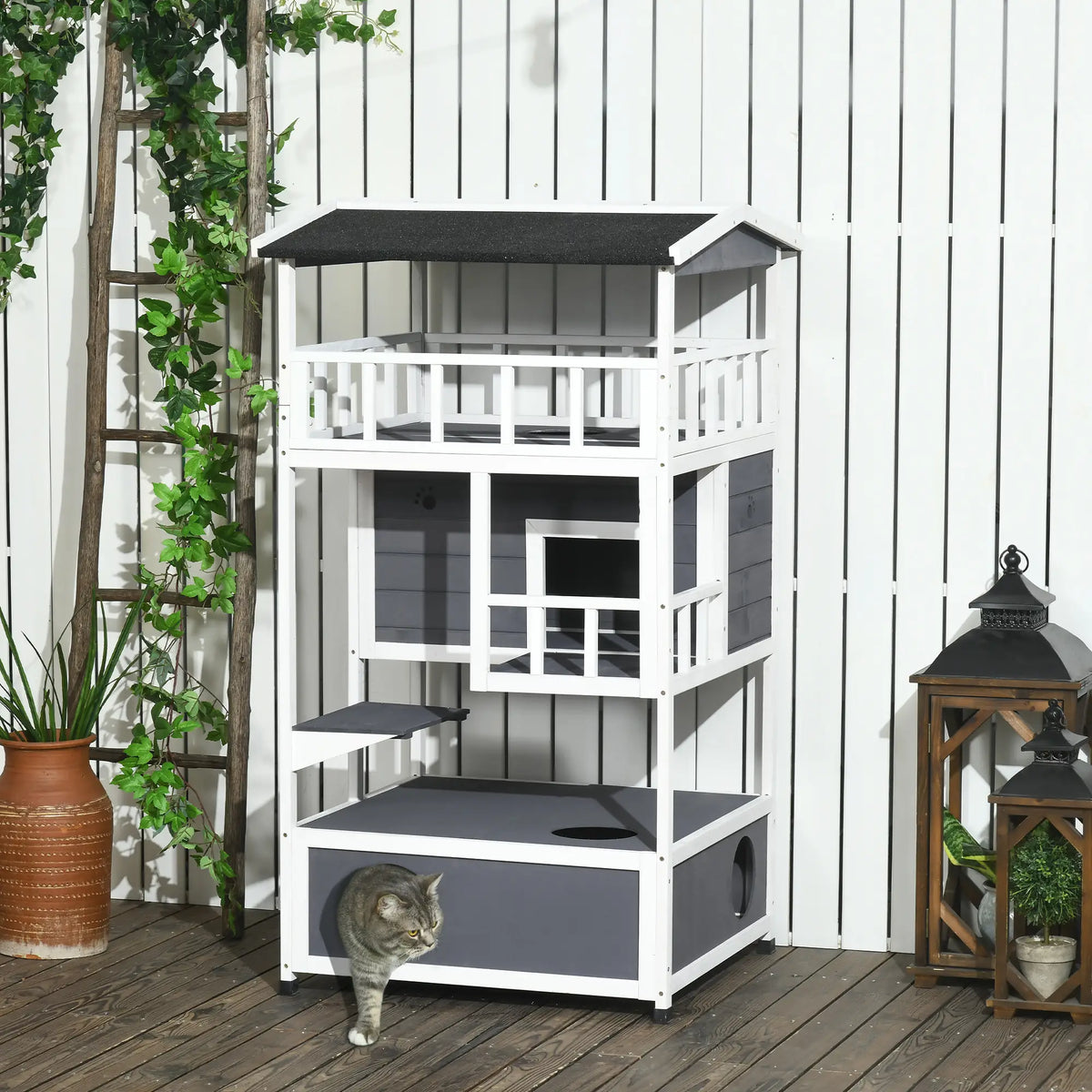 Three-floor wooden outdoor cat house styled on a patio with cats using the different levels