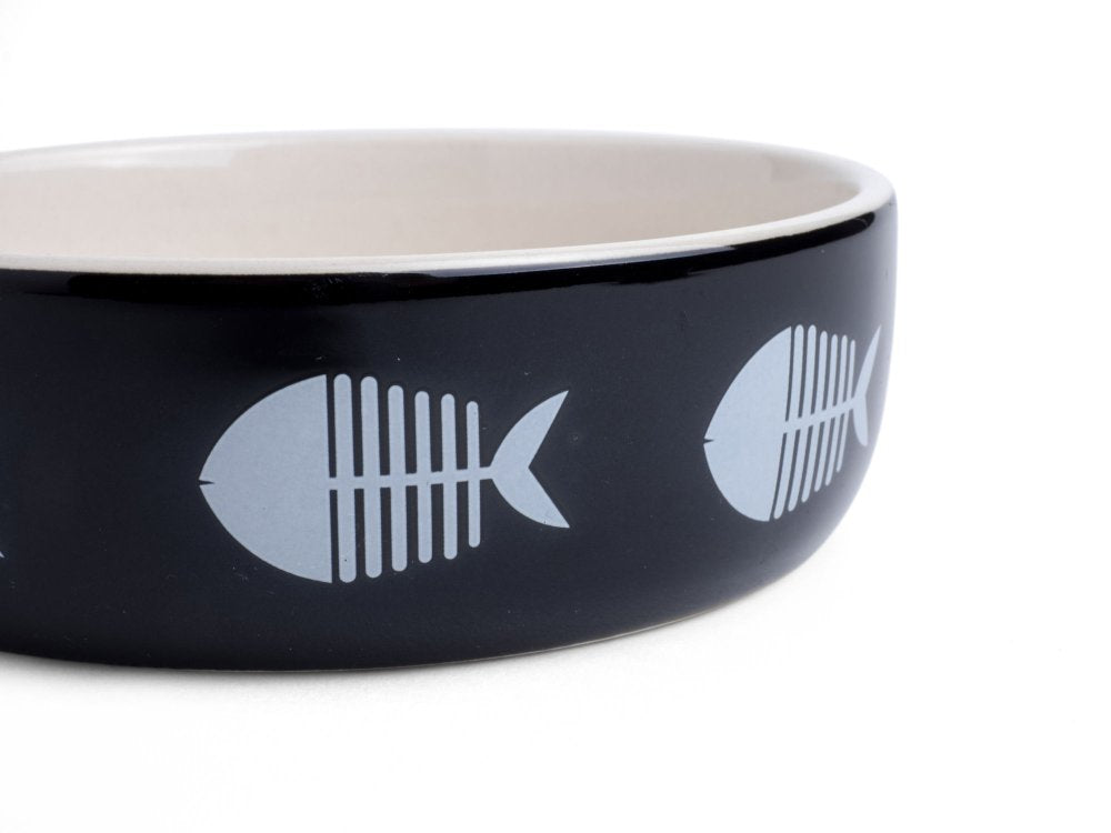 Black pet bowl with fish bone designs on a white background