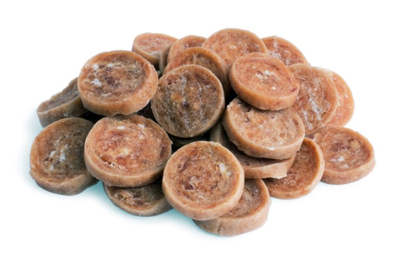 Stack of brown pet treats on a white background