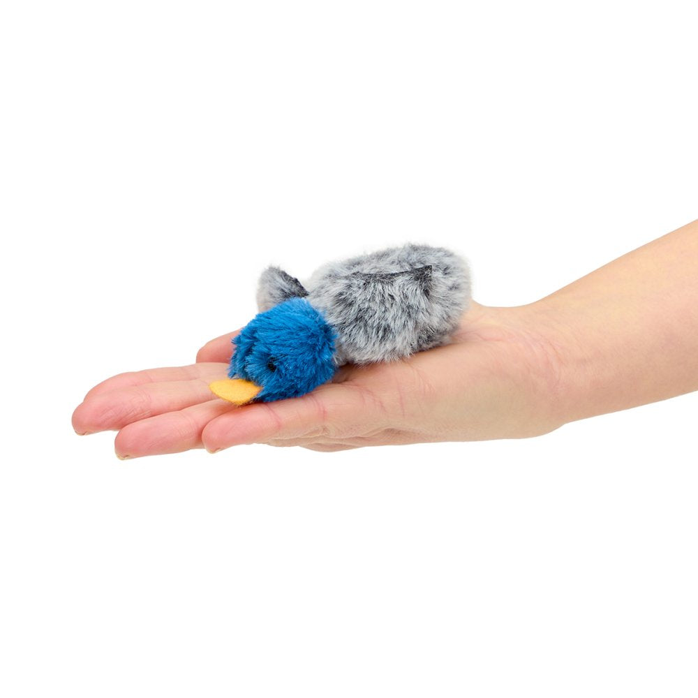 Blue and gray fluffy toy on a person's palm against a white background