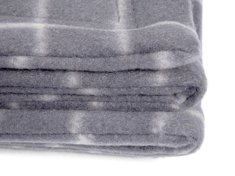 Folded gray blanket with a subtle pattern on a white background