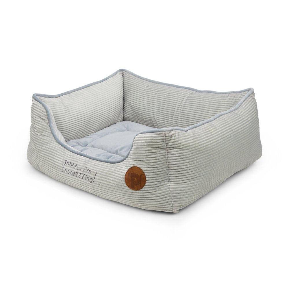 Pet bed with ribbed texture and wooden button on a white background