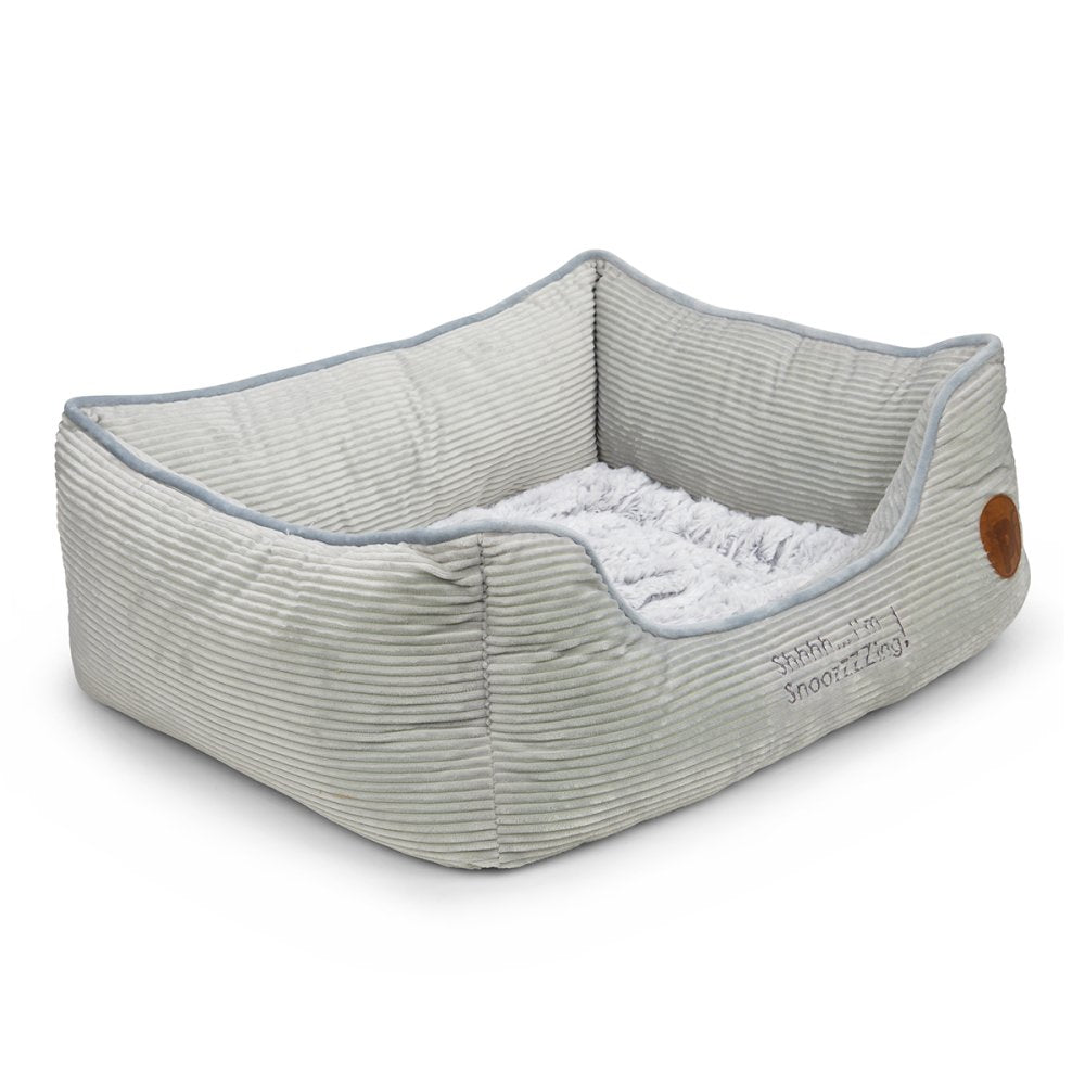 Gray pet bed with a textured surface and brown patch on a white background