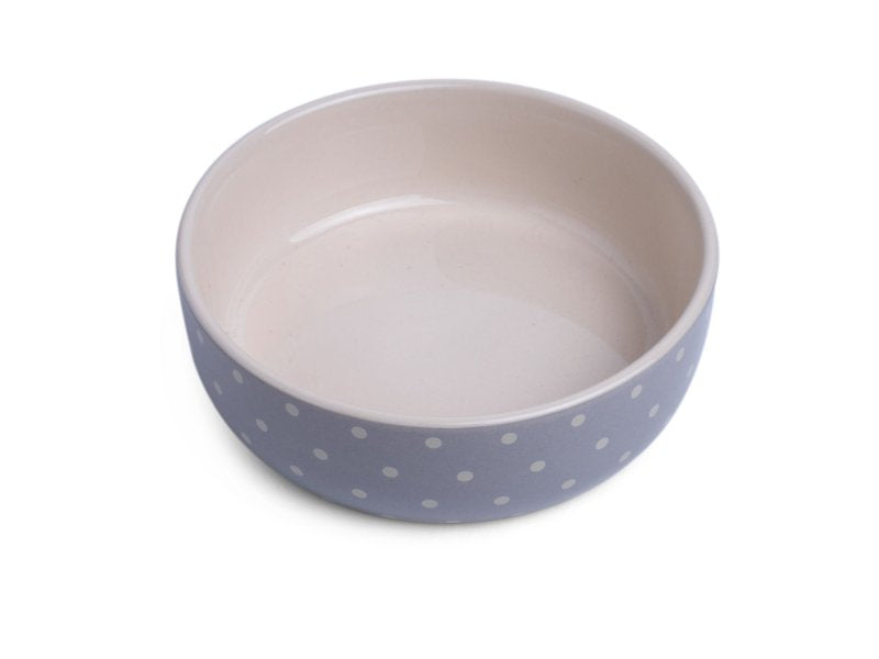 Ceramic bowl with blue exterior and beige interior on a white background