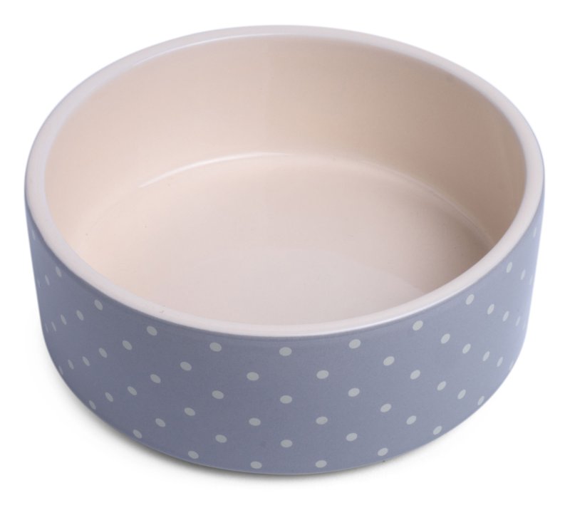 Pet bowl with blue polka dot exterior and beige interior on a white background