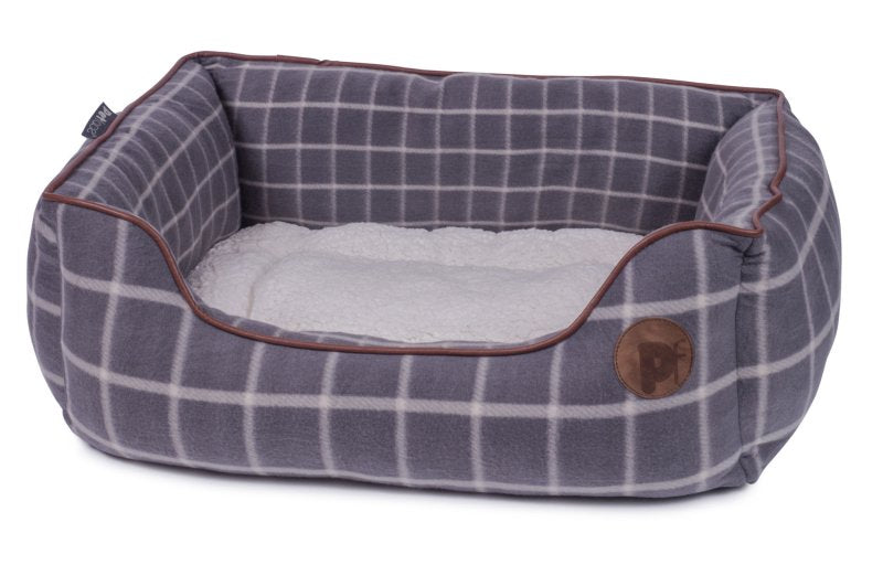 Dog bed with plaid pattern and brown trim on a white background