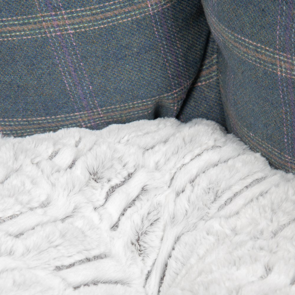 Close-up of a textured white fabric with a plaid blue background
