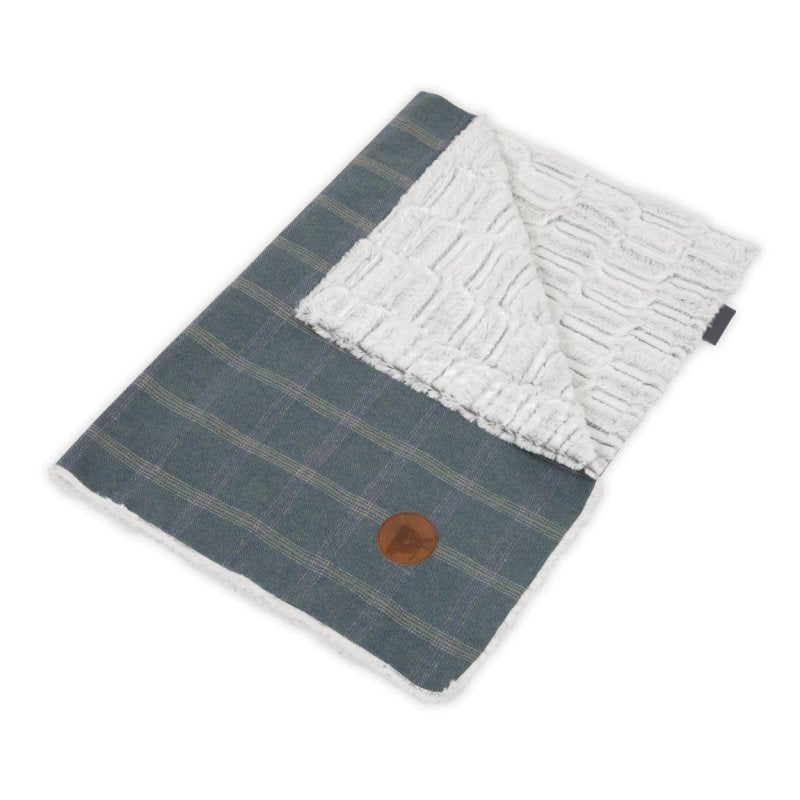 Folded fabric with plaid pattern on one side and textured white pattern on the other, on a white background.