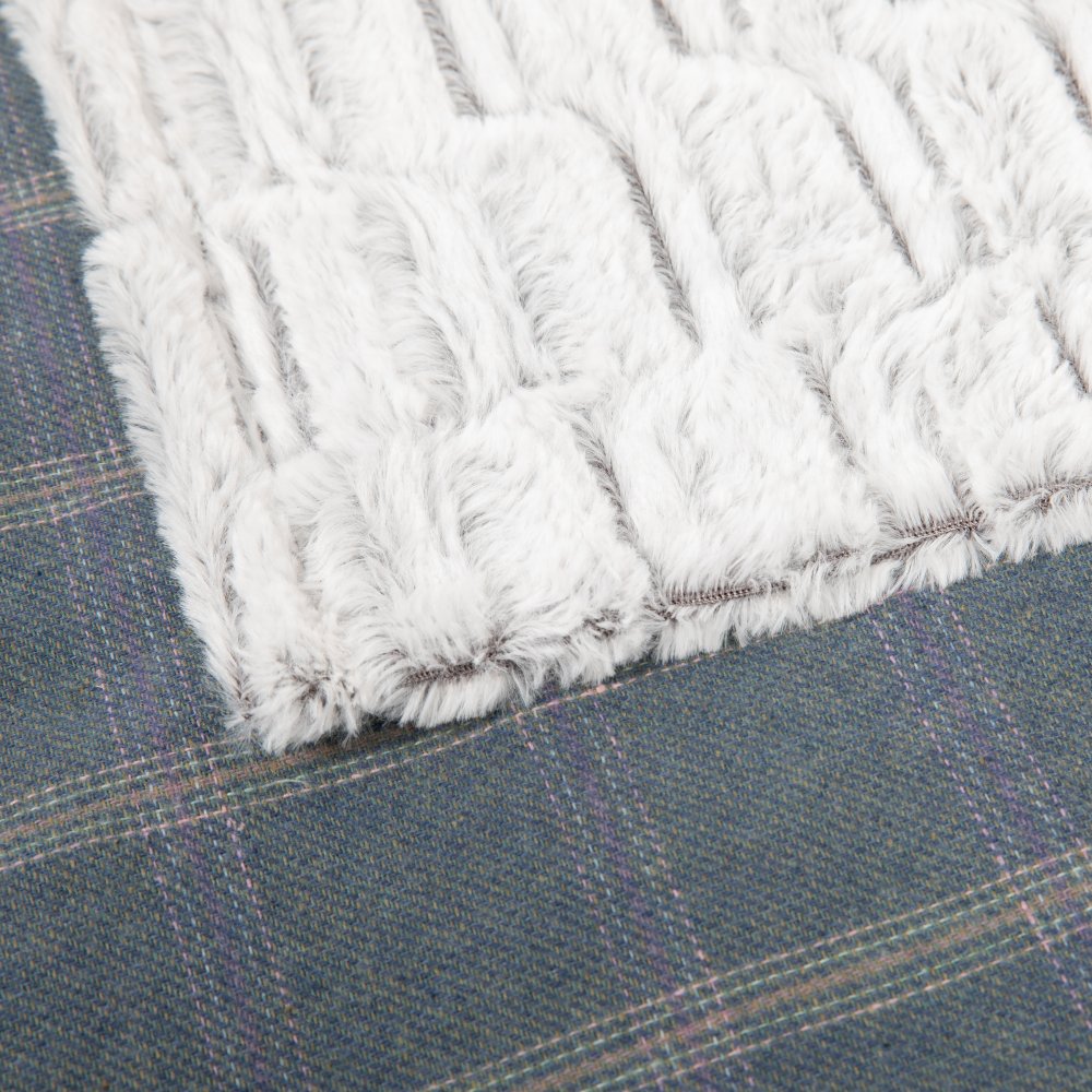 Close-up of a textured white fabric edge on a plaid fabric background