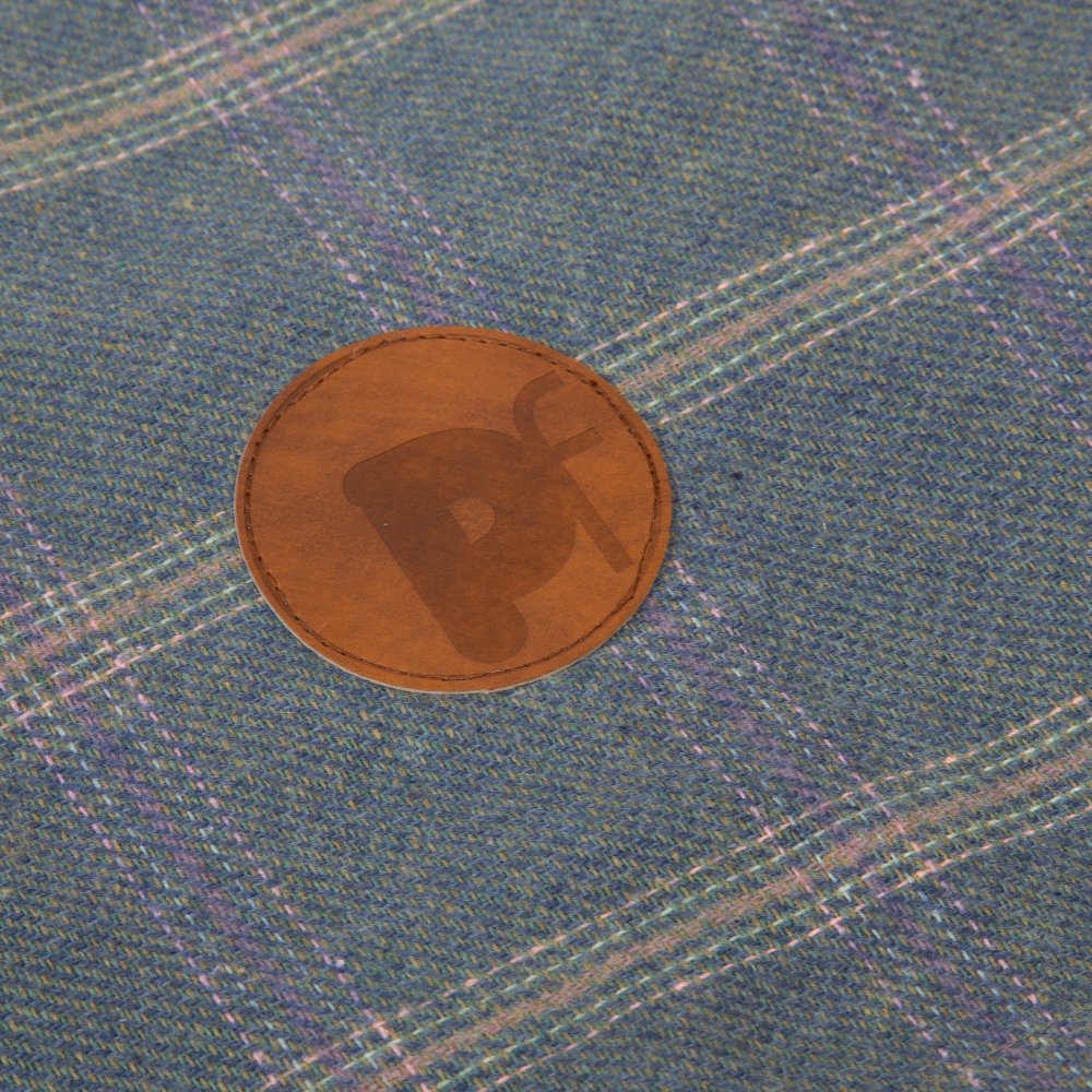 Brown patch with a logo on a textured blue fabric background