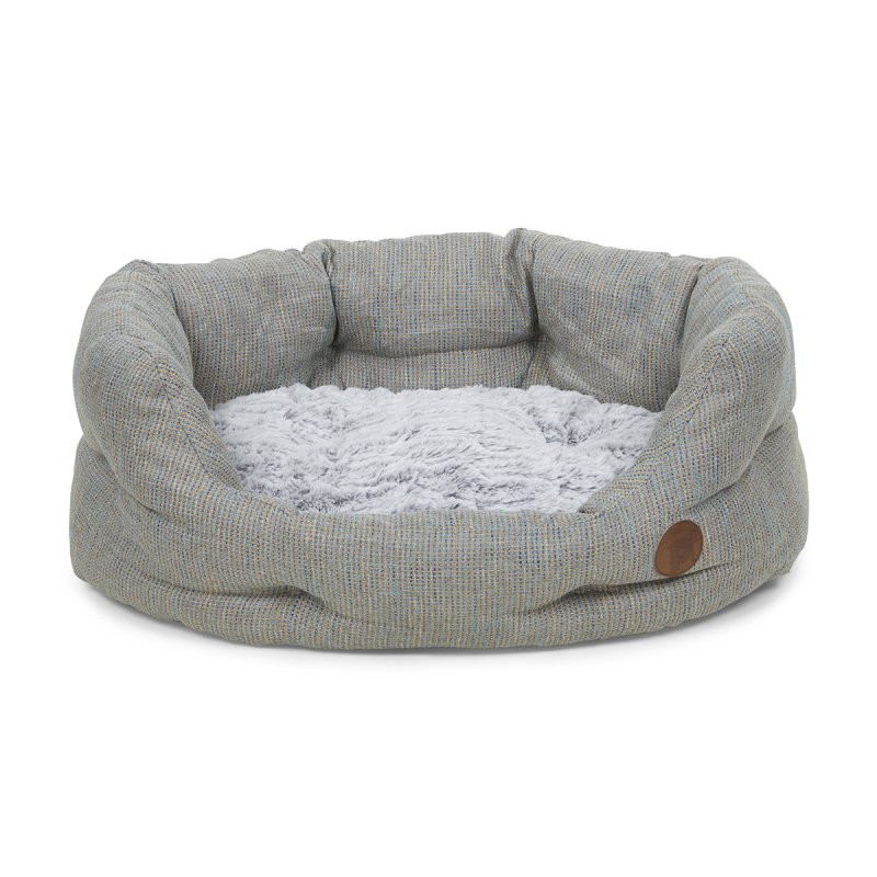 Dog bed with gray fabric exterior and fluffy white interior on a white background