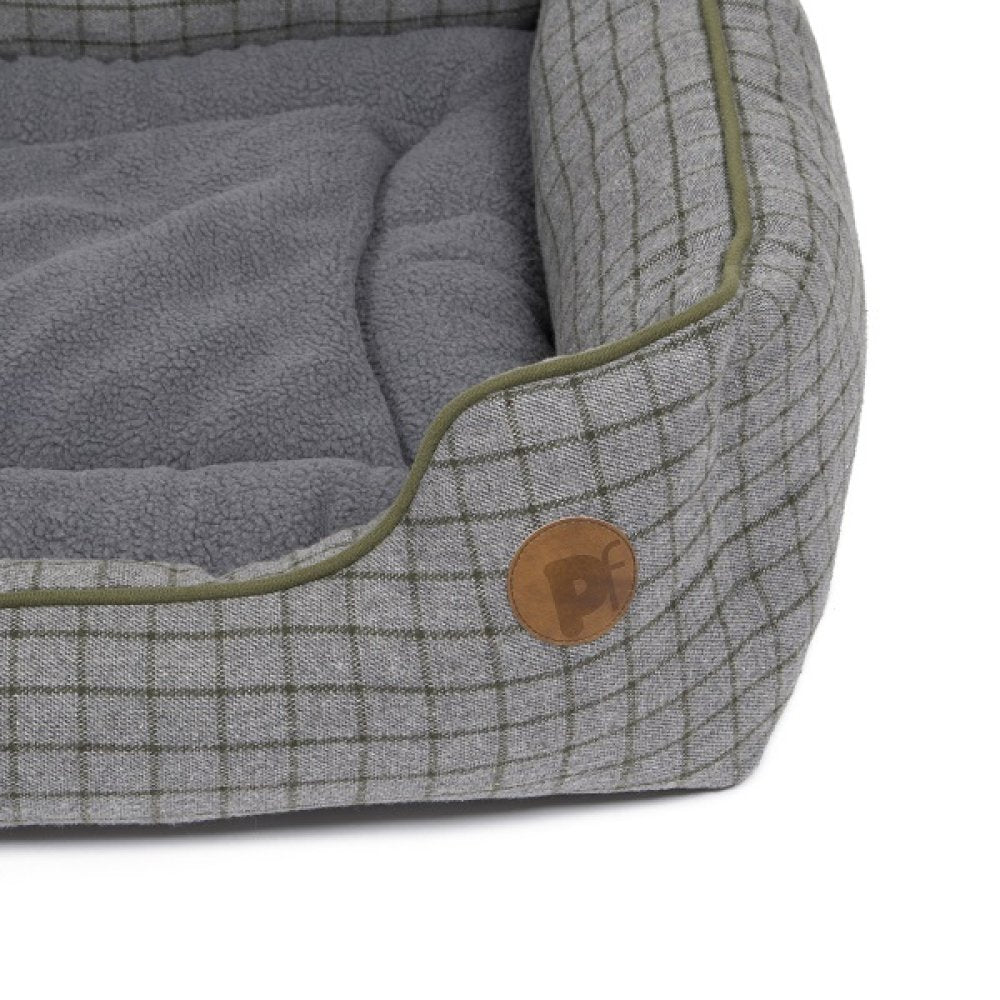 Gray pet bed with plaid pattern and brown button on a white background