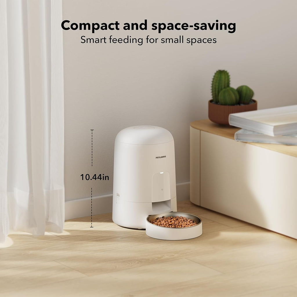 Compact pet feeder on a wooden floor with text highlighting its space-saving design.