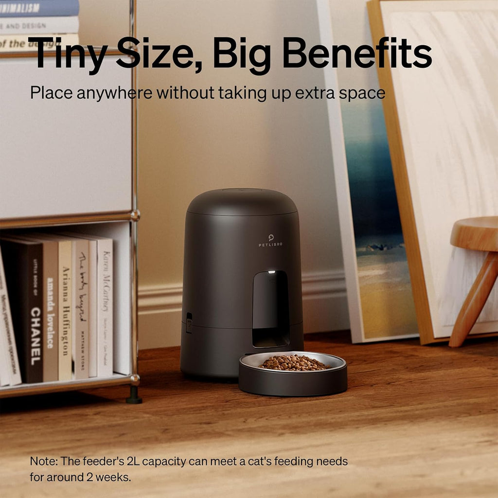 The Petlibro 2 Litre Automatic Pet Feeder on a wooden floor in a domestic setting. 