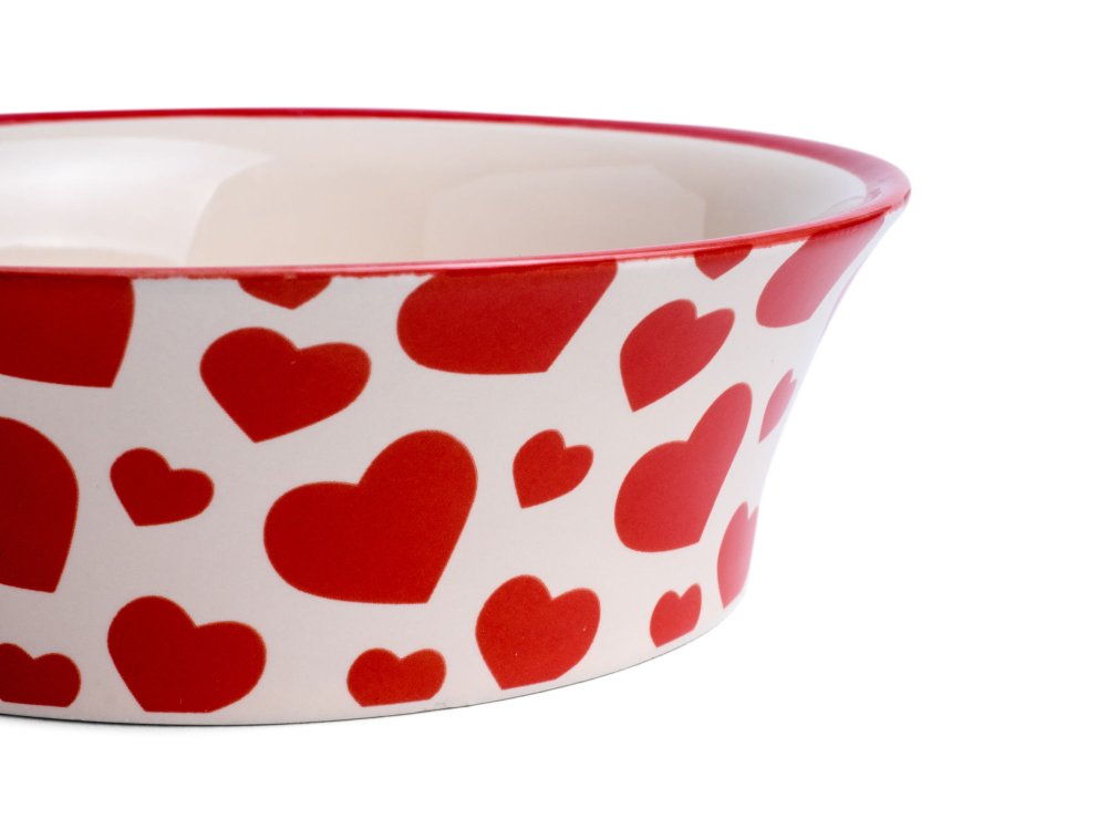Ceramic bowl with red heart patterns on a white background