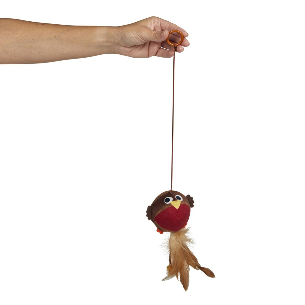 Hand holding a small bird-shaped toy with a string against a white background