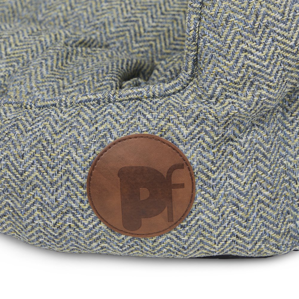 Textured fabric surface with a brown leather patch featuring a logo on a white background