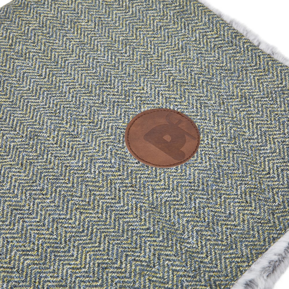 Textured fabric with a brown leather patch featuring a logo.