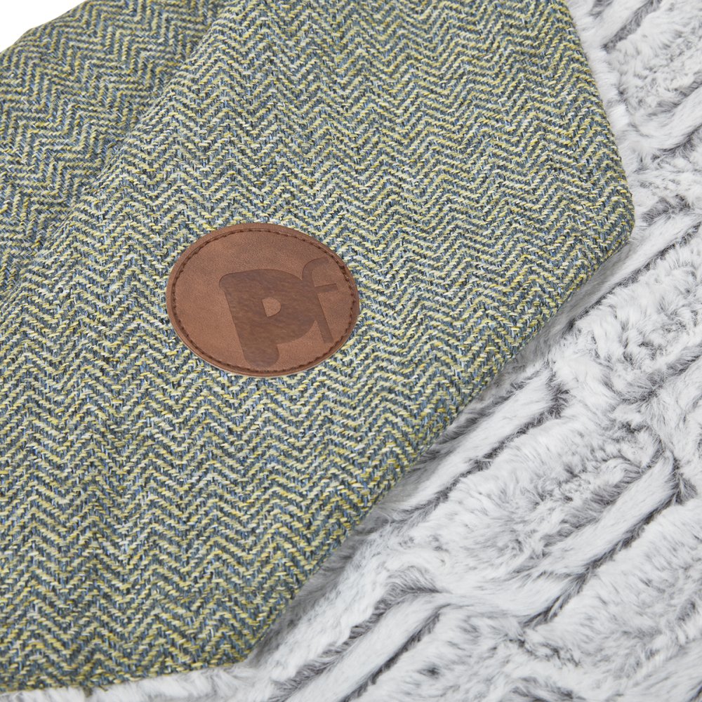 Textured fabric with a brown leather patch featuring a letter 'P' on a textured surface.