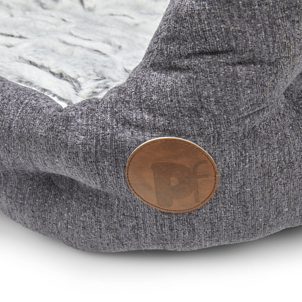 Gray textured dog bed with a brown leather patch on a light gray background
