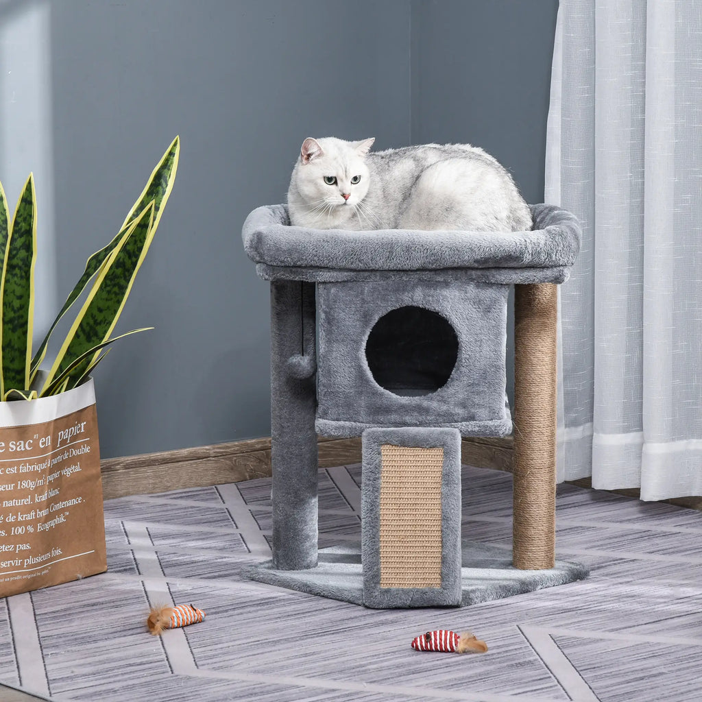 Cat sitting on a gray cat tree with a plant and toys in the background