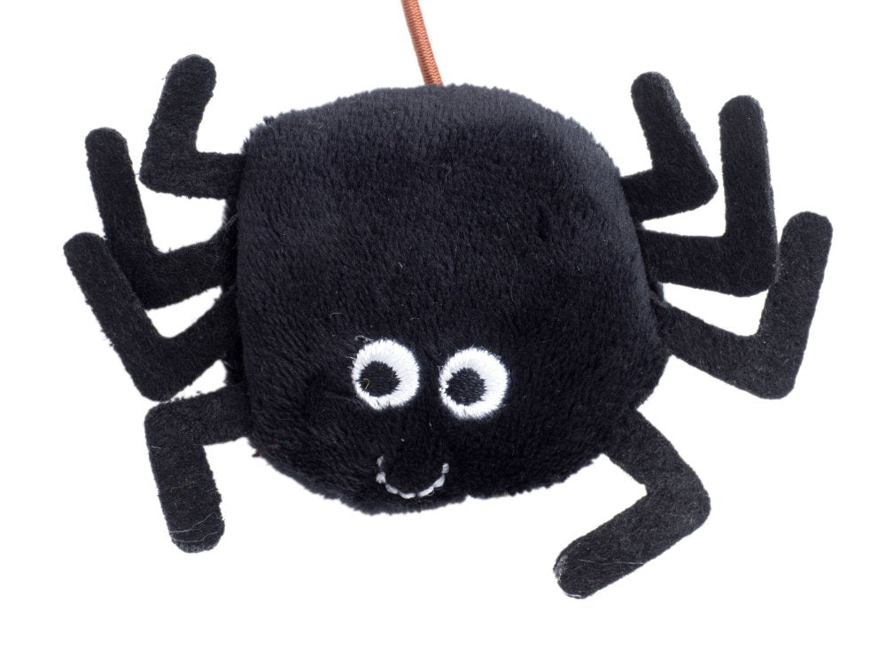 Black spider-shaped toy with googly eyes on a white background