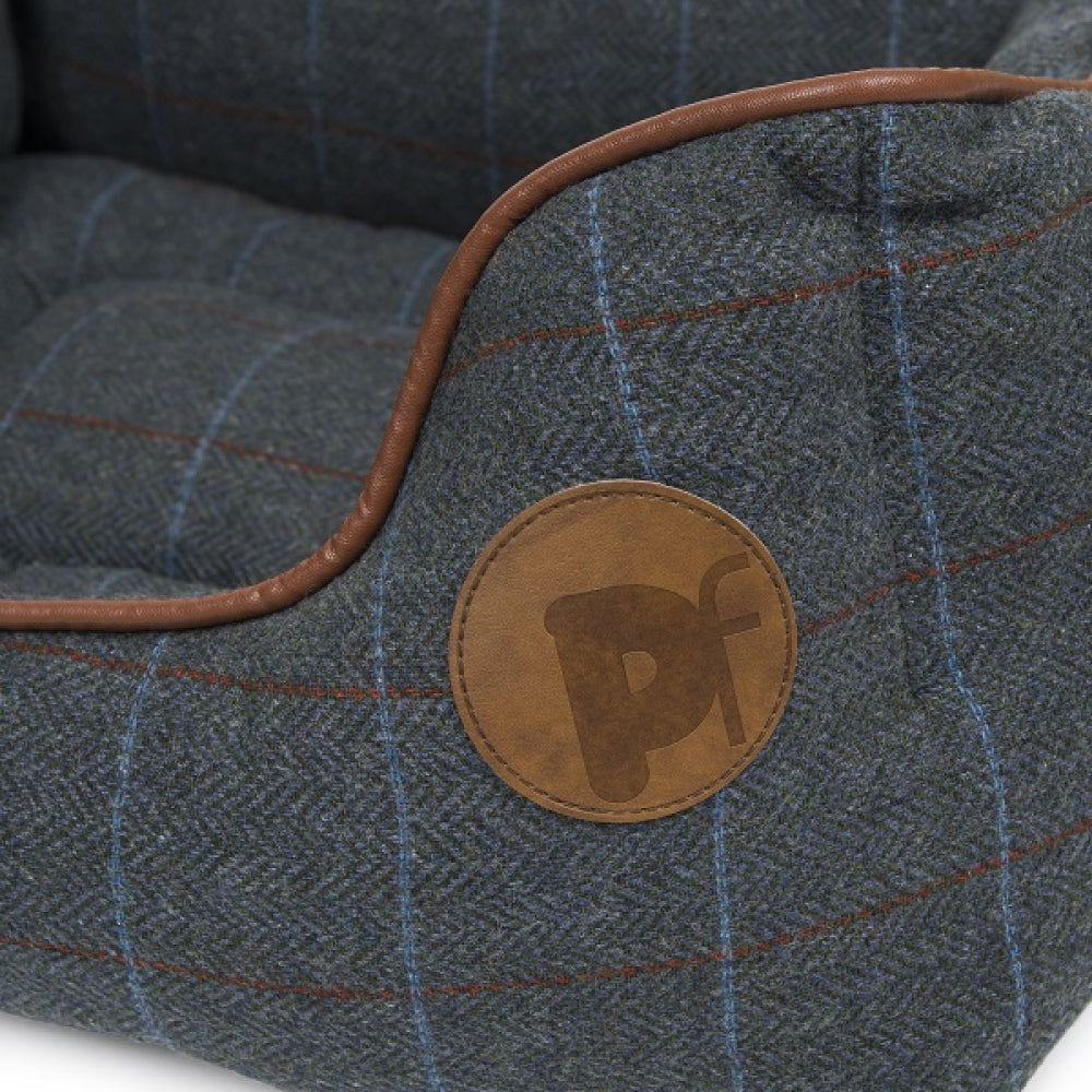 Close-up of a textured fabric surface with a brown leather patch featuring a logo.